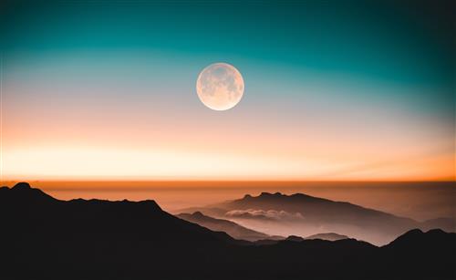 moon at moonrise over mountains